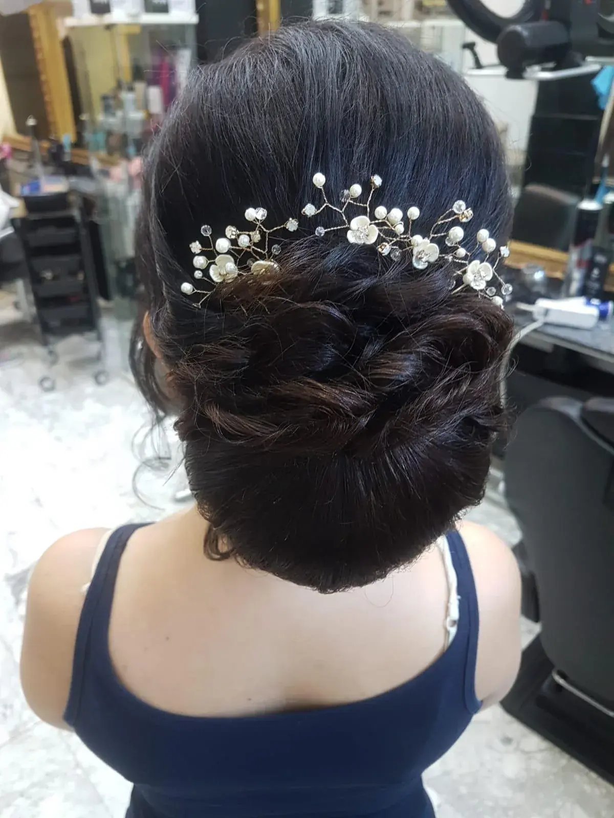Recogido bajo para evento decorado con flores y perlas en Zache
